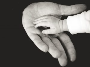 A man holding a baby's hand.