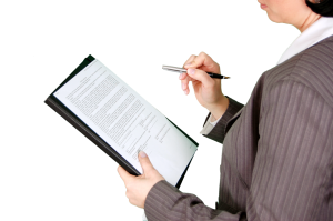 A woman holding some documents and a pen