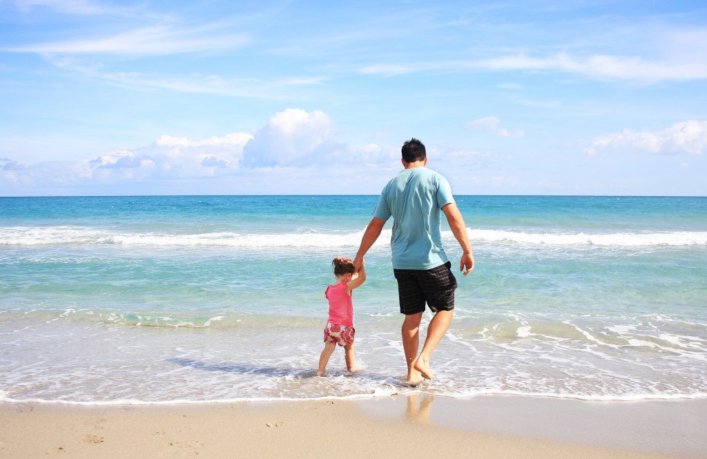 A man and a child on the beach.