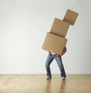 Man carrying three boxes alone as one of the downsides of DIY moving