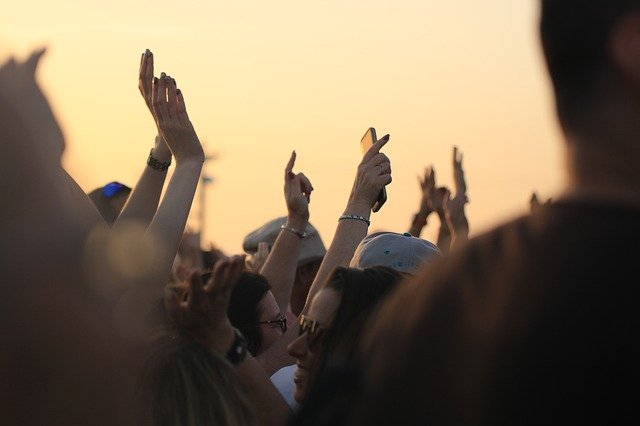 people in a festival with their arms up in the air