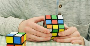 man solving rubicks cube with the patience he will use when relocating a movie set