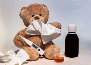 A teddy bear with a fever and some medicine