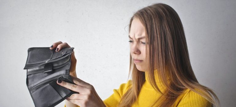 Woman frowning at her wallet.