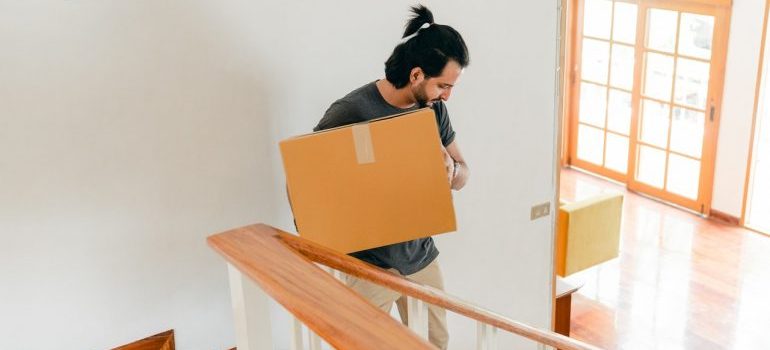A man carrying a box down the stairs