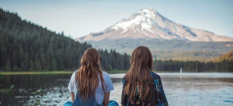 Two girls looking over a lake in Oregon, after hiring the best cross country movers Salem has to move them there.