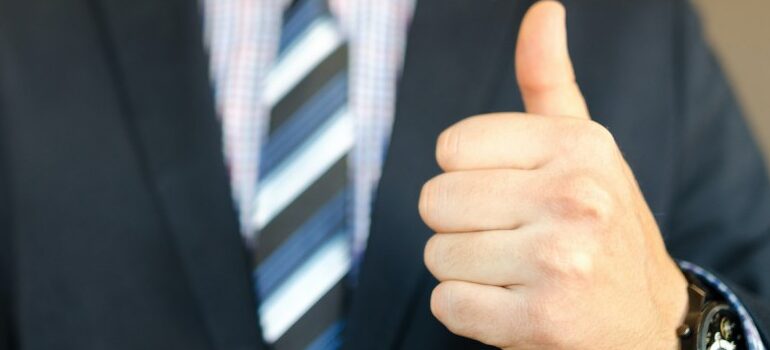 male in a suit, thumbs up