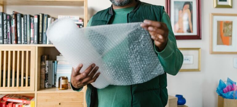 A man holding wrapping materials for packing.