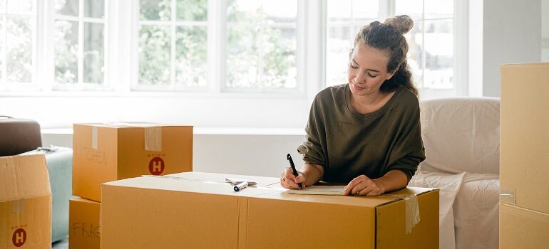 woman marking a moving box