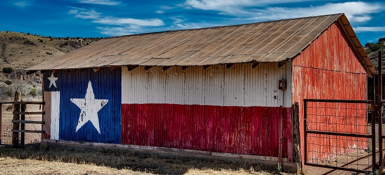 a barn with a Texas flag on it