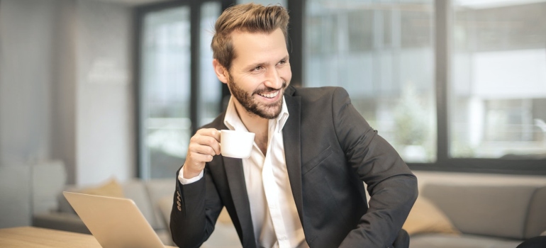 a man smiling with a coffee