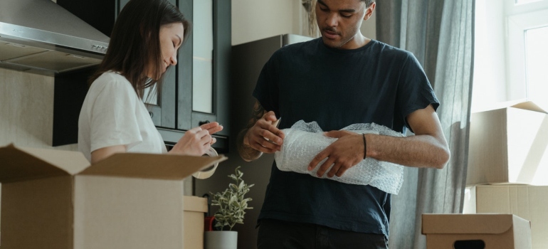 A man and woman packing a moving box