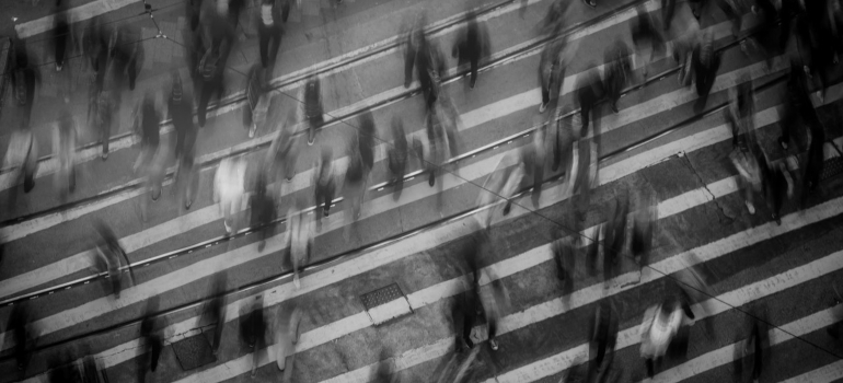a black and white photo of a large number of people crossing the street - Americans' reasons for moving