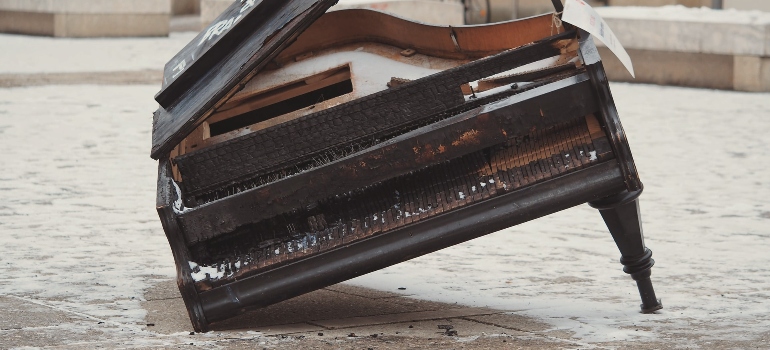 A broken piano on the street.