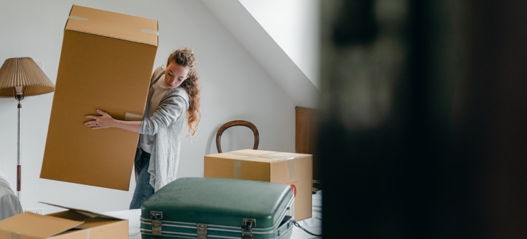 Woman carrying boxes in new apartment