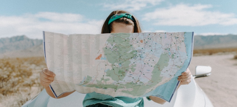 A woman looking at the map searching for the most popular small cities to relocate