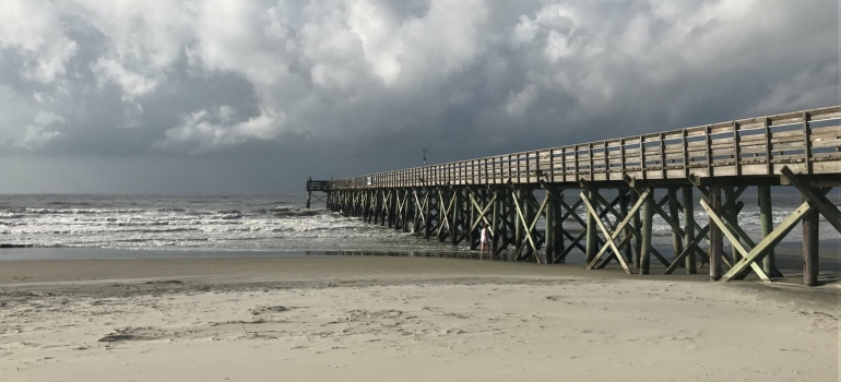 a picture of a dock stretching into the ocean in Charleston, South Carolina