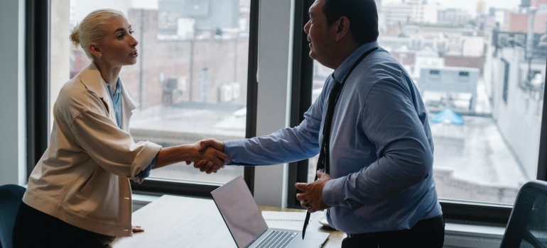 a woman and a man shaking hands after a job interview