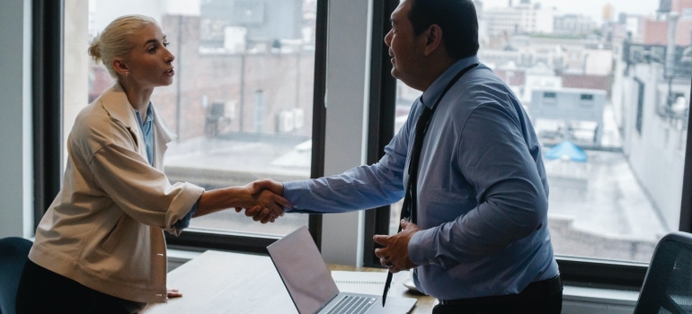 a man and a woman shaking hands after finishing a business interview to depict what salary do you need to live in NYC