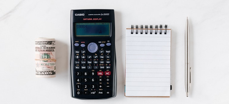 calculator with paper money and notebook with pen