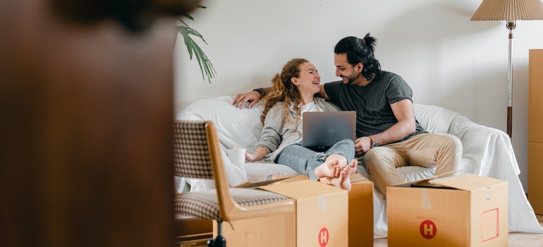 A happy couple reading a blog about the things you should look for in a professional moving company