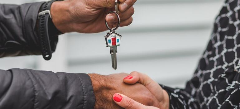 A real estate agent giving a key to their client