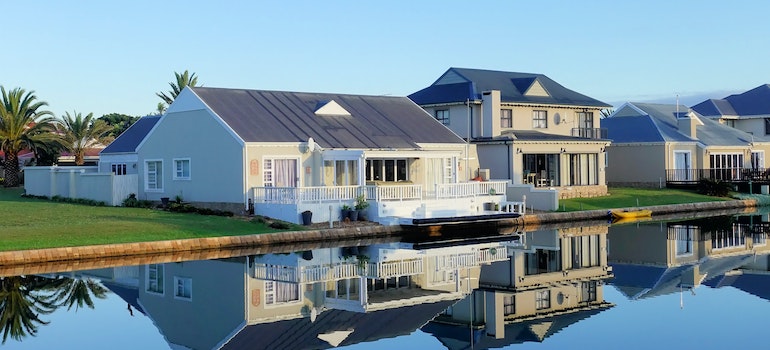 White Single-story Houses Beside Body of Water.