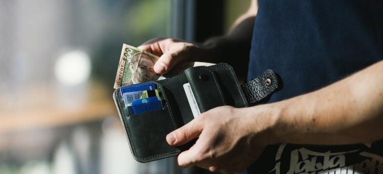 a man putting money in his wallet 