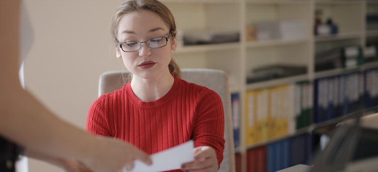 Young woman examines a document in the office.