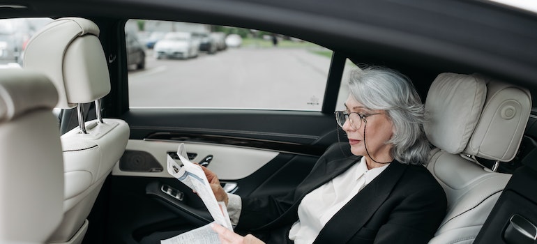 A Businesswoman Reading a Newspaper - bonus nationwide moving expenses.