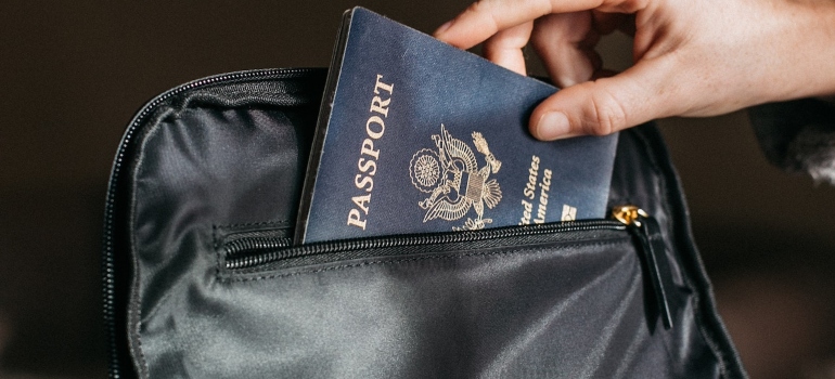 a person putting a passport in their bag
