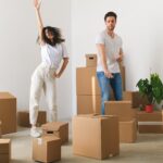 Joyful young couple dancing after moving into a newly purchased apartment
