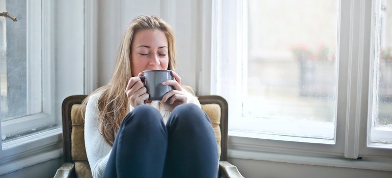 A woman sitting and enjoying her coffee